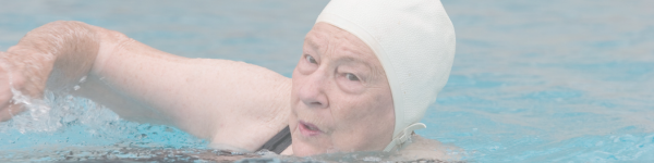 Image of a senior woman swimming laps in a pool.