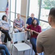 Image of a speaker giving a presentation for a small group of veterans of varying age, gender and ethnicity. 