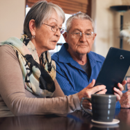 Image of a senior couple reviewing information on a tablet.