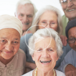 Image of a group of elderly women. A "play" symbol overlays the image signifying that clicking this image will play a video.