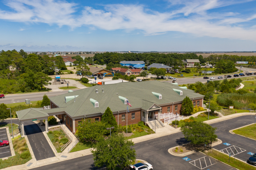 Aerial image of a brick building called the Virginia S. Tillett Community Center, situated beside a road.