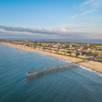 Aerial image of the Outer Banks, featuring a pier in the ocean.