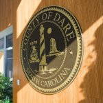 Image of the Dare County seal/logo displayed on a wooden wall.