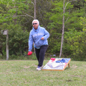 Image of a woman playing cornhole during the senior games.