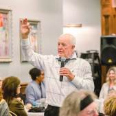 Image of Chairman Woodard speaking into a microphone to a crowd.