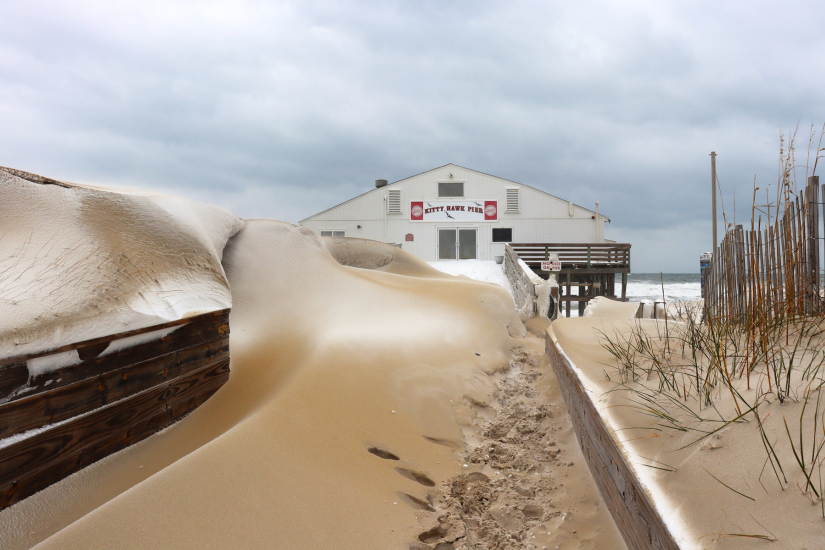 Image of snow capped dunes in front of the Kitty Hawk Pier House during a rare Outer Banks winter snow storm.
