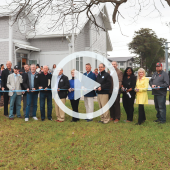 Image of a group of elected officials cutting a ceremonial ribbon in front of the new Youth Center. Click this image to play a recap video.