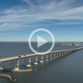 Aerial image of the Washington Baum Bridge. A play button signifies that a video about the waterline project will play when clicked. 