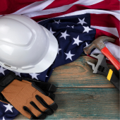 Image of tools and a helmet sitting beside a USA flag.