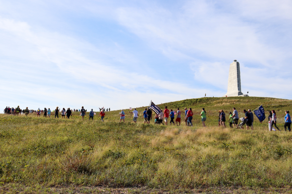 Image of a line of people marching up the Wright Brother