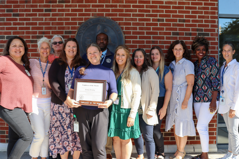 Dare County Foster Care Social Worker Jessica Brickey stands with her colleagues who attended the presentation.