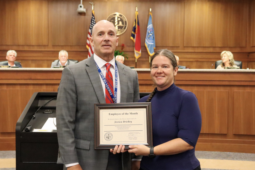 Dare County Social Services Division Director Chuck Lycett presents the certificate to Foster Care Social Worker Jessica Brickey.