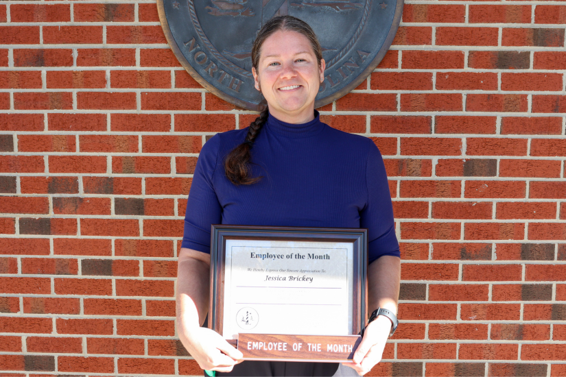 Dare County Foster Care Social Worker Jessica Brickey holds her Employee of the Month certificate.