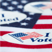 Image of "I Voted" stickers resting on an American flag.
