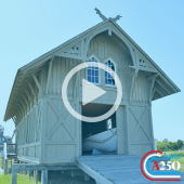 Image of the Chicamacomico Lifesaving Station. A play button signifies that a video will play when clicked. Image contains Dare A250 logo watermark.