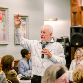 Image of Dare County Board of Commissioners Chairman Bob Woodard speaking to a crowd using a microphone.