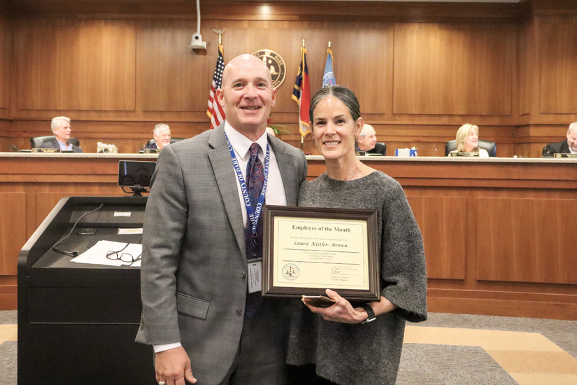 Image of Chuck Lycett presenting the award to Laura Kistler-Brown during the meeting.