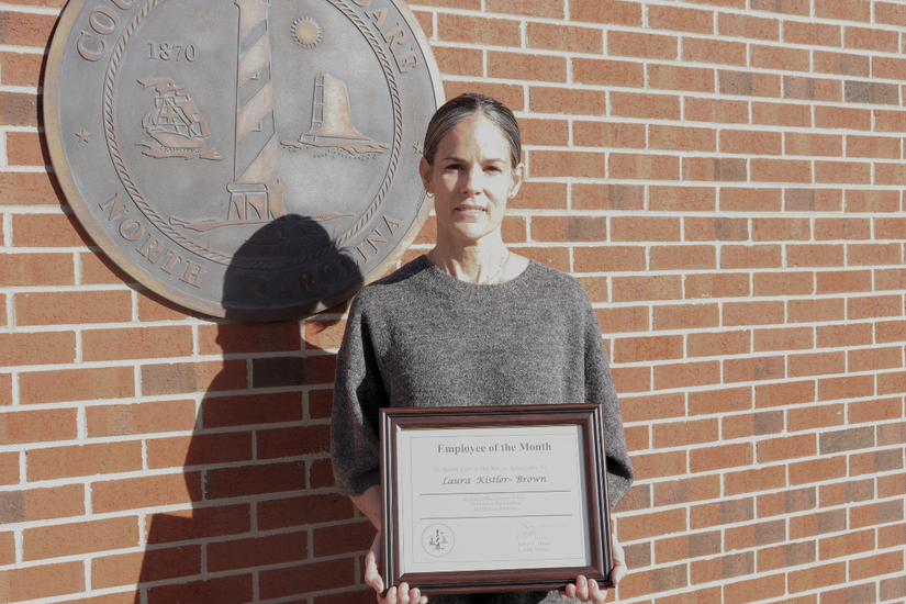 Image of Laura Kistler-Brown holding her Employee of the Month certificate.