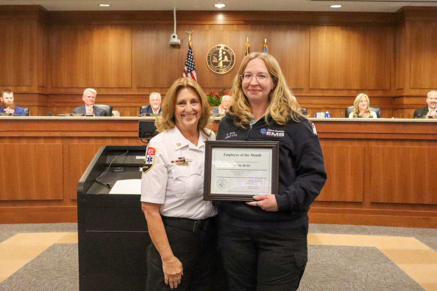 Chief Jennie Collins presents the certificate to Kirsten “Schae” Britt during the Dare County Board of Commissioners meeting.