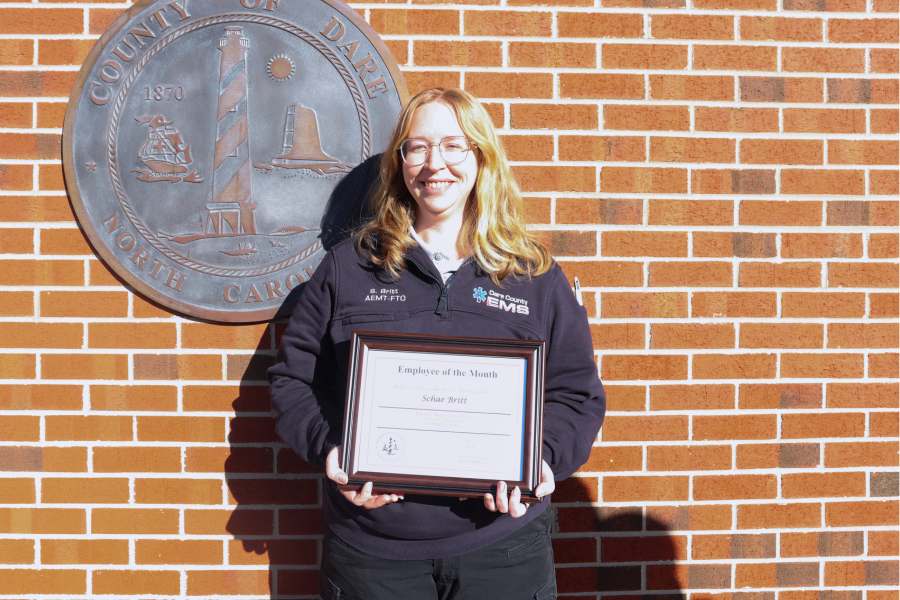 Image of Kirsten “Schae” Britt holding her Dare County Employee of the Month certificate.