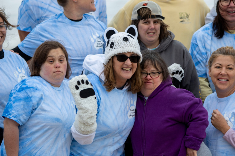 Image of volunteers and plungers lined up to run into the water.