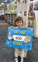 Child holding "I've read 400 books before kindergarten" sign
