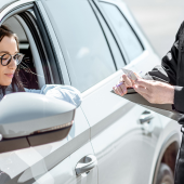 Image of a woman showing her ID to a police officer at a traffic stop.