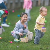 Image of small children on an easter egg hunt in the grass.