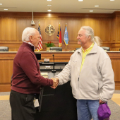 Chairman Woodard shakes Murray Parker's hand.