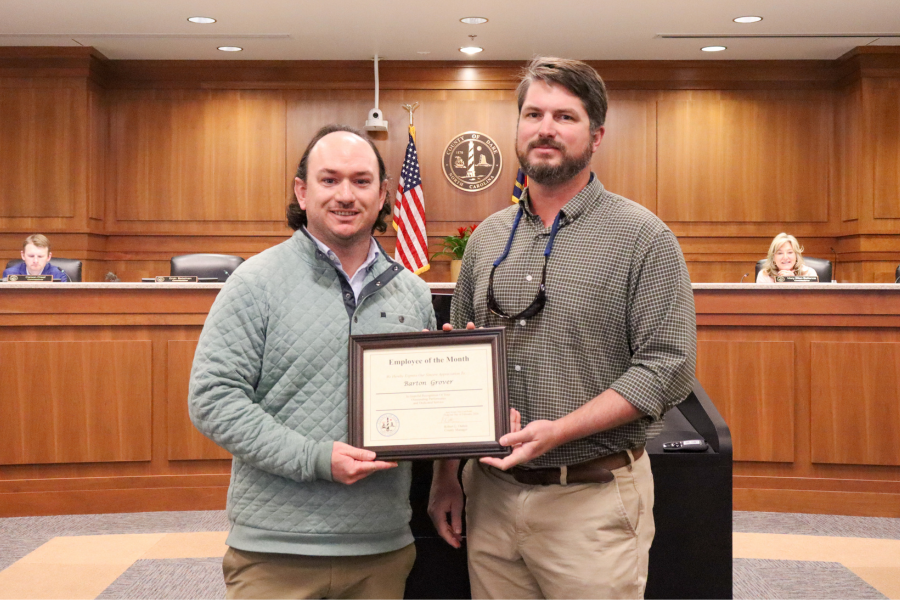Noah Gillam (right) presents the Employee of the Month certificate to Barton Grover (left).