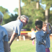 Coach helping young soccer players.