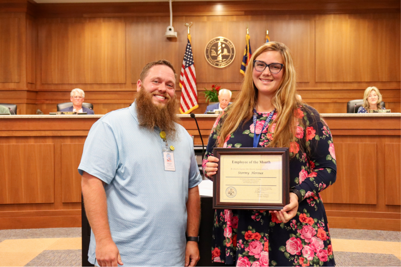DHHS front office manager Jeremy Harvey presents the award to Stormy Heroux