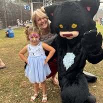 Children's Librarian with smiling child and Bad Kitty character at KidsFest 2025