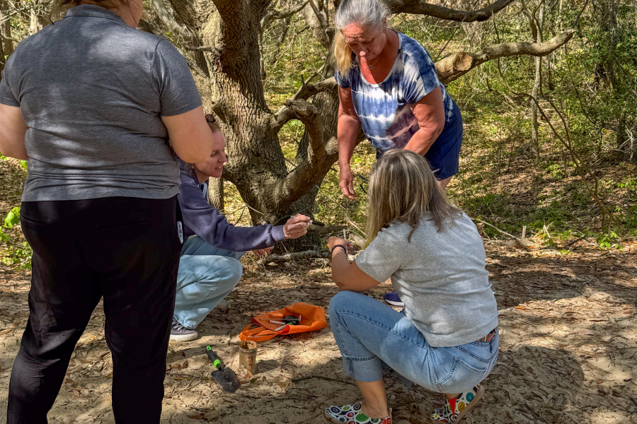 Image of teachers hands on working on an experiment outdoors.
