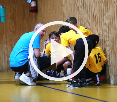 Image of Dare County Parks and Recreation players and volunteer on the court with a play button