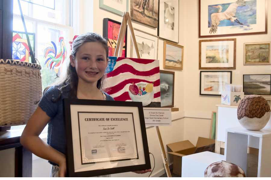 Image of Emma Zoe Cahill sitting with her artwork in the Dare Art gallery.