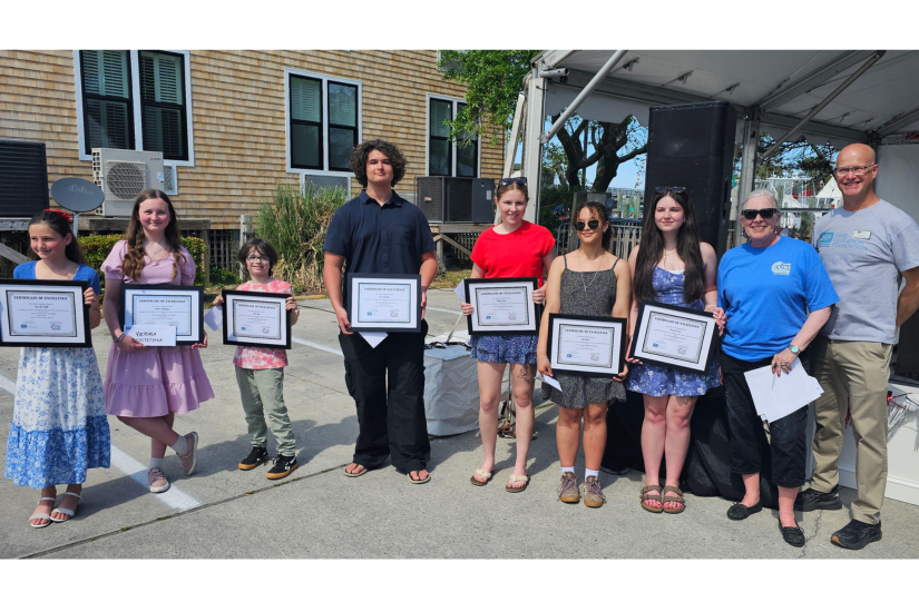 The students hold up their framed certificates.