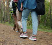 Image of people's legs as they walk along a trail.