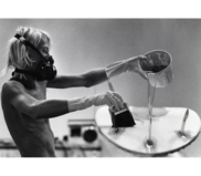 Image of a young man pouring resin to glass the bottom surf board in Kill Devil Hills in 1990
