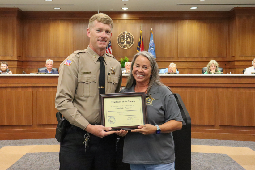 911 Communications Director Captain David Saffell presents the award to Telecommunicator Elizabeth Farmer during the meeting.