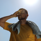 Image of a man overheating under bright sunlight