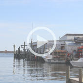 Image of well-worn fishing boats at the docks along the marina in Wanchese, NC.