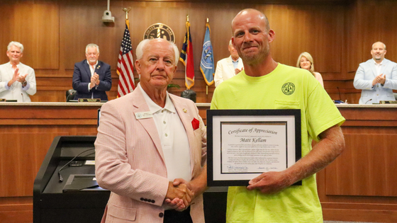 Chairman Woodard presented a framed certificate to Matt Kellam, shaking his hand.