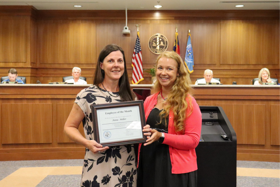 School Nurse Supervisor Mandi Ferguson presents the certificate to Anna Miller during the Dare County Board of Commissioners meeting.