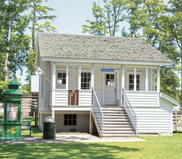 Image of a small white building with a sign that reads, "Pea Island Cookhouse"