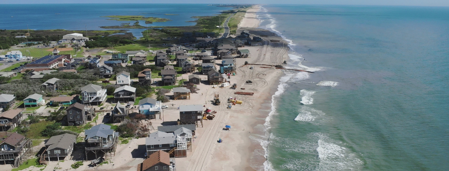 Aerial image showing beach nourishment progress and equipment on the beach in Buxton.