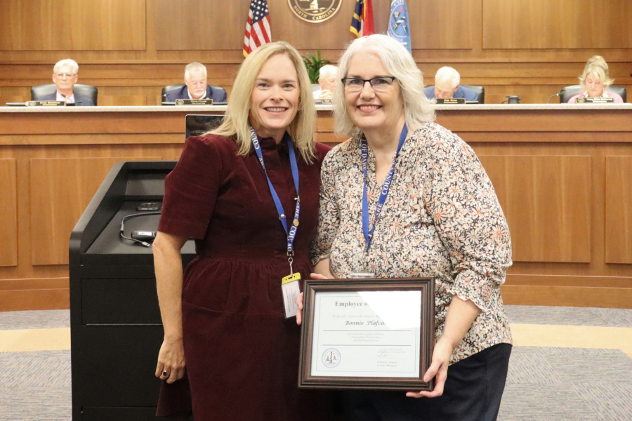 Human Resources Director Elizabeth Reilly presents a framed certificate to Bonnie Plafcan