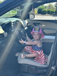Festive kid in a police car at the Fourth on First Avenue event