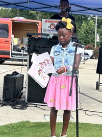 Student reads a book selection at Knightdale Arts and Education Festival, August 16, 2025)