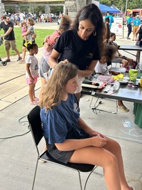 Student gets hair braided at Knightdale Arts and Education Festival, August 16, 2025)